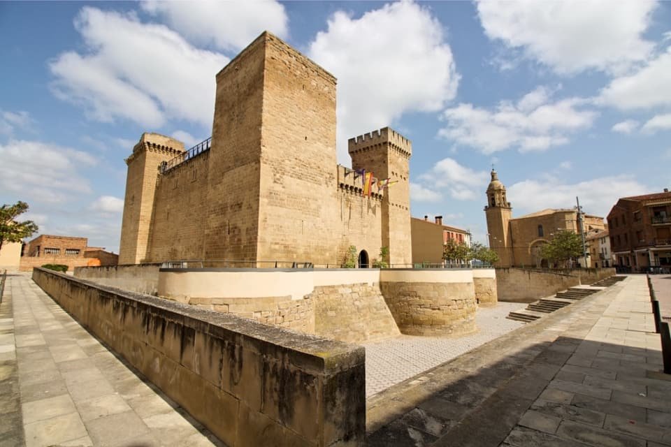 Castillo de Aguas Mansas, en Agoncillo, con sus torres de piedra y la torre de la iglesia al fondo