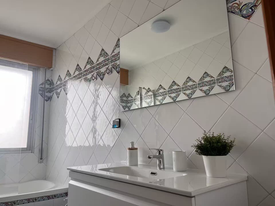 Baño de la Casa B con bañera, lavabo y azulejos decorados